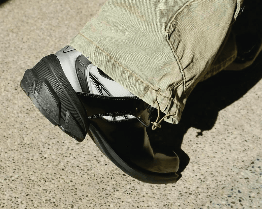 Remagine sneaker in black and white mid-step under a khaki trouser hem